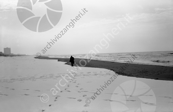 Neve in spiaggia Spiaggia riva mare costa neve uomo che cammina impronte