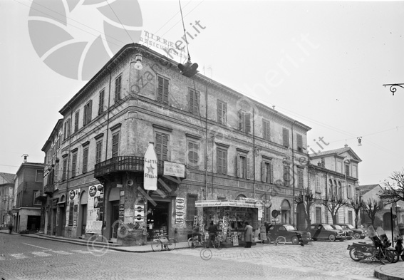 Palazzo Fabbri all'angolo fra Piazza Fabbri e via Carbonari Latte stella bar Martini edicola bicicletta caffè Roversi Gancia auto parcheggiate Enalotto il resto del Carlino il Corriere della Sera avanti la voce repubblicana la stampa il giorno l'avvenire l'unità motori