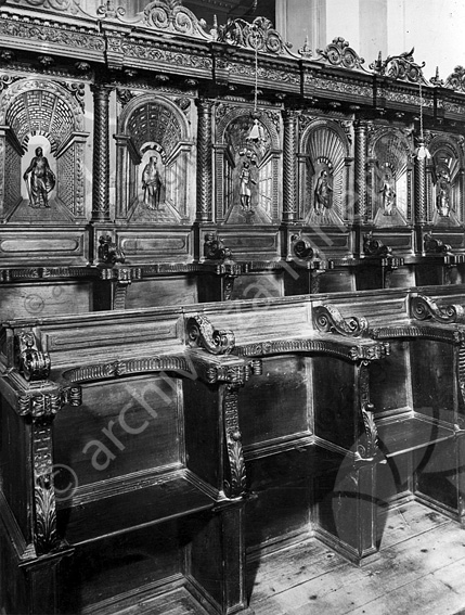 Sedute in legno del coro nell'abside della Basilica del monte particolare Bassorilievi lignei sedute panche poltrone