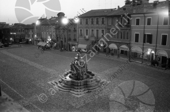 Fontana Masini e piazza del Popolo vista dal Comune Portici cartoleria libreria Minerva UNIvesti vetrine negozi notturna albergo cappello tabacchi