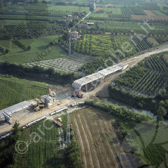 Aerea cantiere costruzione ponte sul Ronco gru travi fiume campi