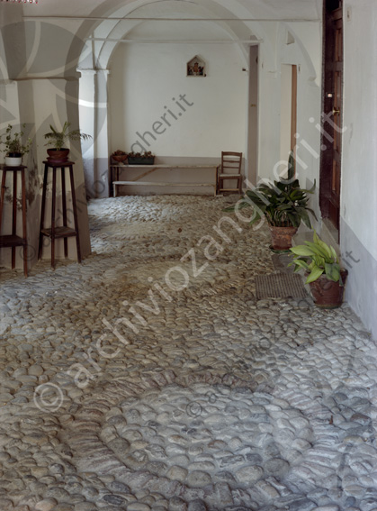 Sogliano portico Pavimento di sassi sedie vasi di fiori