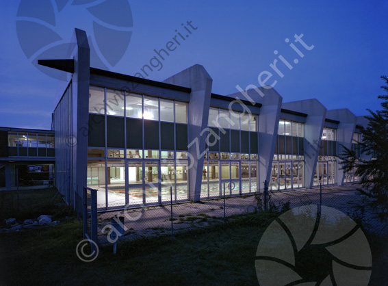 Piscina comunale di Cesena esterno Centro Natatorio Comunale di Cesena Colonne in cemento armato vetrate notturna