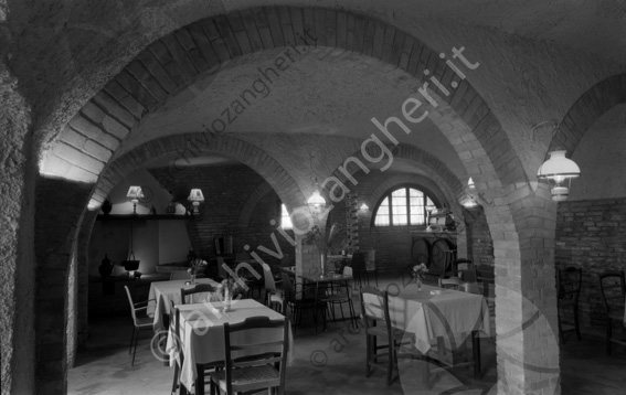 Albergo Rubicone Lido Taverna la Buca archi seminterrato cantina tavole apparecchiate sedie lampadari lampade camino penombra