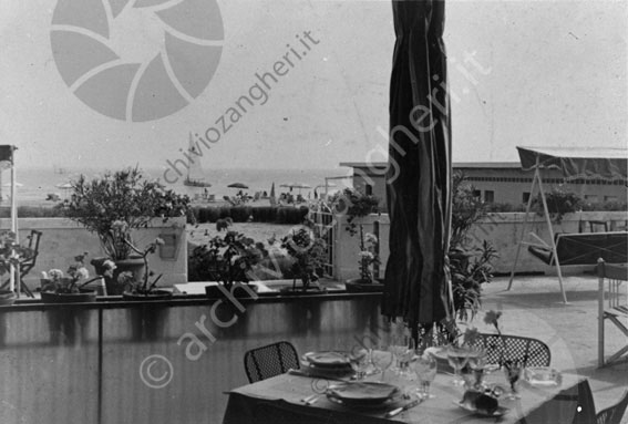 Grand Hotel di Cervia particolare terrazza e spiaggia tavola apparecchiata piatti bicchieri posate mare barca spiaggia dondolo ombrelloni