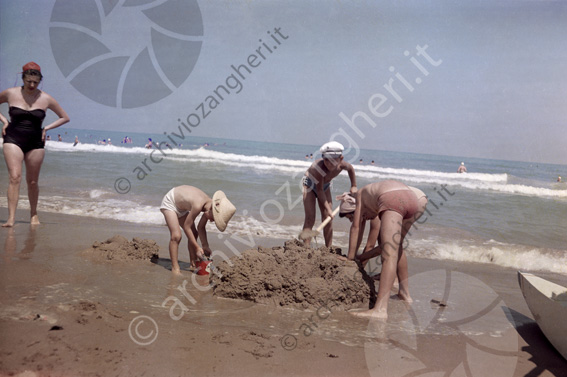 bimbi che giocano con la sabbia a riva mare