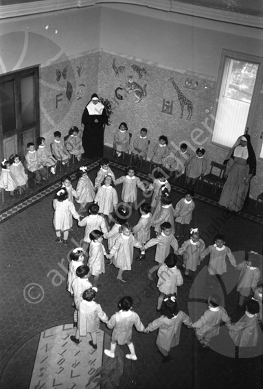 Asilo di Sarsina bimbi che giocano nel salone Via Roma, 24 suore ballare danzare in cerchio bambini 