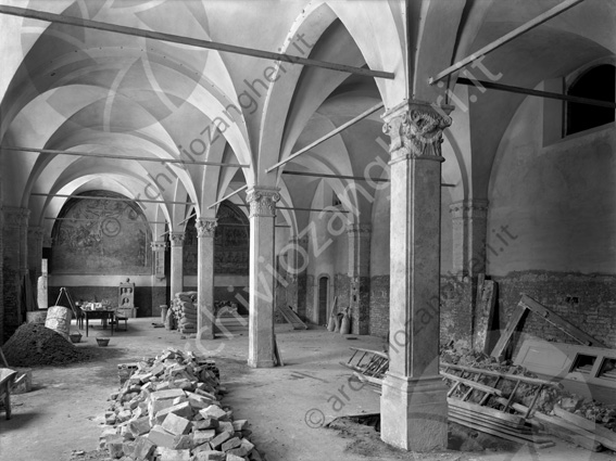 Biblioteca Malatestiana interno refettorio scala sacchi tavolo lavori colonne capitelli mattoni macerie 
