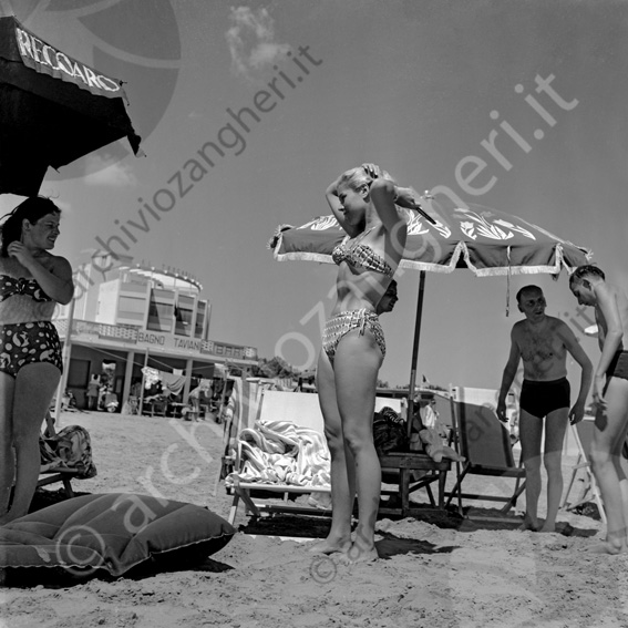 Ragazza in spiaggia all'ombrellone Bagno Taviani (ora Bagno Azzurro) Bella ragazza pettinare pettinarsi sdraio ombrellone stabilimento balneare materassino bagno Taviani costume da bagno