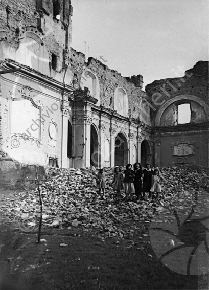 Gruppo tra le rovine all'interno della chiesa di San Rocco dopo il bombardamento aereo del 1944 Gruppo di ragazze chiesa distrutta bombardata ruderi macerie distruzione bambine